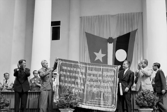 Trong ảnh: Trong chuyến thăm hữu nghị chính thức Lào từ ngày 15 – 18/7/1977, Tổng Bí thư Lê Duẩn và Thủ tướng Phạm Văn Đồng thay mặt Trung ương Đảng và Chính phủ Việt Nam trao tặng Trung ương Đảng và Chính phủ Lào bức trướng thêu 4 câu thơ nổi tiếng của Chủ tịch Hồ Chí Minh: “Thương nhau mấy núi cũng trèo. Mấy sông cũng lội, mấy đèo cũng qua. Việt - Lào hai nước chúng ta. Tình sâu hơn nước Hồng Hà Cửu Long”. Ảnh: TTXVN