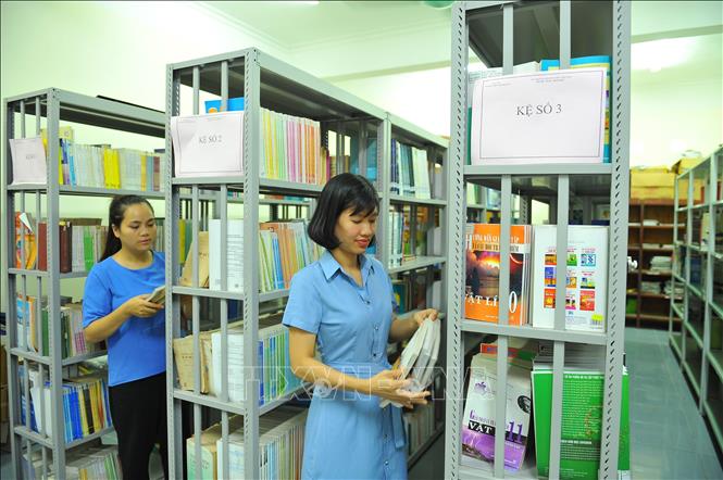 Trong ảnh: Các cán bộ của trường xắp xếp lại sách trong thư viện Ảnh: Minh Đức - TTXVN