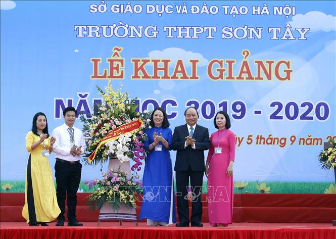 Trong ảnh: Thủ tướng Nguyễn Xuân Phúc tặng hoa cho thầy trò Trường THPT Sơn Tây. Ảnh: Thống Nhất – TTXVN
