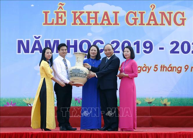 Trong ảnh: Thủ tướng Nguyễn Xuân Phúc tặng quà cho thầy và trò Trường THPT Sơn Tây. Ảnh: Thống Nhất – TTXVN

