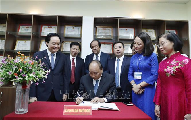 Trong ảnh: Thủ tướng Nguyễn Xuân Phúc lưu bút tại phòng truyền thống tại Trường THPT Sơn Tây.  Ảnh: Thống Nhất – TTXVN

