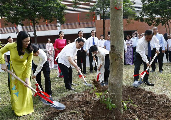 Trong ảnh: Bí thư Thành ủy Hà Nội Hoàng Trung Hải cùng các đại biểu trồng cây lưu niệm tại khuôn viên nhà trường. Ảnh: Văn Điệp - TTXVN