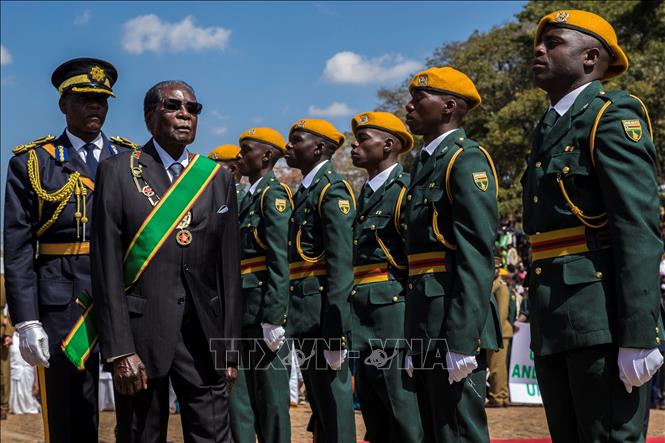 Trong ảnh: (tư liệu) cựu Tổng thống Zimbabwe Robert Mugabe (thứ 2 trái) duyệt đội danh dự tại một lễ kỷ niệm ngày 14/8/2017. Ảnh: AFP/TTXVN