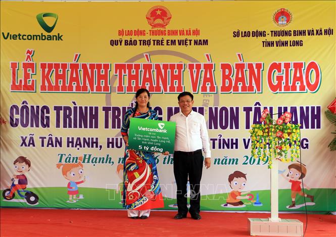 Trong ảnh: Lãnh đạo Ngân hàng thương mại cổ phần ngoại thương Việt Nam trao bảng tượng trưng tài trợ 5 tỷ đồng xây dựng Trường Mầm non Tân Hạnh. Ảnh: Phạm Minh Tuấn-TTXVN.