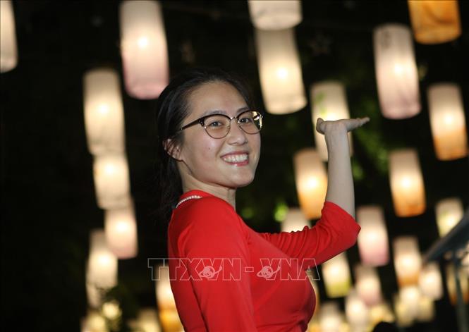 Trong ảnh: Các bạn trẻ say sưa tạo dáng, ghi lại những khoảnh khắc đẹp dưới ánh đèn lồng. Ảnh: Thanh Tùng-TTXVN
