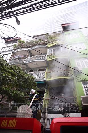 Trong ảnh: Lực lượng Phòng cháy, chữa cháy cùng với 3 xe cứu hỏa chuyên dụng đang nỗ lực chữa cháy và giải cứu các nạn nhân trong nhà. Ảnh: Dương Giang-TTXVN