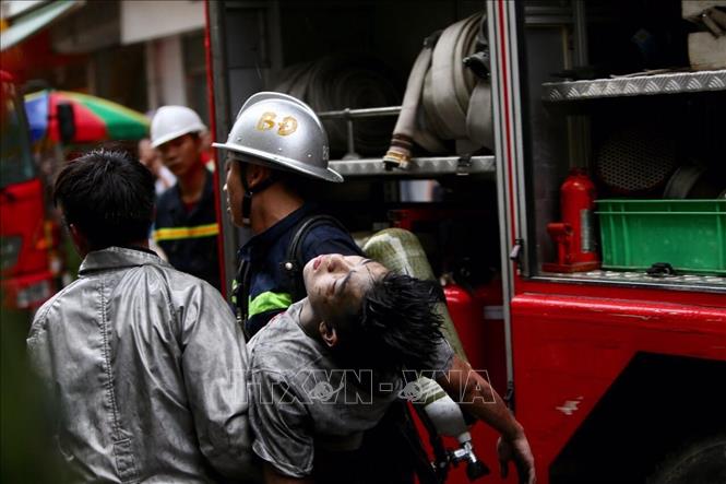 Trong ảnh: Nạn nhân cuối cùng được đưa ra khỏi đám cháy. Ảnh: Dương Giang - TTXVN