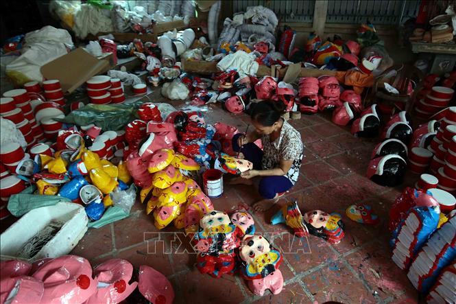 Trong ảnh: Mặt nạ được những nghệ nhân tỉ mẩn vẽ mô phỏng lại các nhân vật dân gian. Ảnh: Phạm Kiên - TTXVN