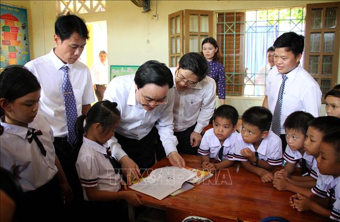 Trong ảnh: Bộ trưởng Phùng Xuân Nhạ với thầy trò Trường tiểu học Tân Hoá, huyện Minh Hóa (Quảng Bình). Ảnh: Văn Tý-TTXVN