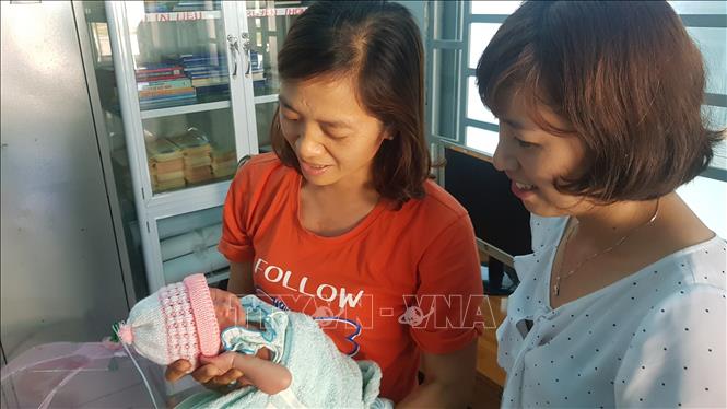 Trong ảnh: Bé sơ sinh bị bỏ rơi trước cổng chùa đang được chăm sóc tại trạm y tế xã Nghĩa Trung. Ảnh: Đậu Tất Thành - TTXVN