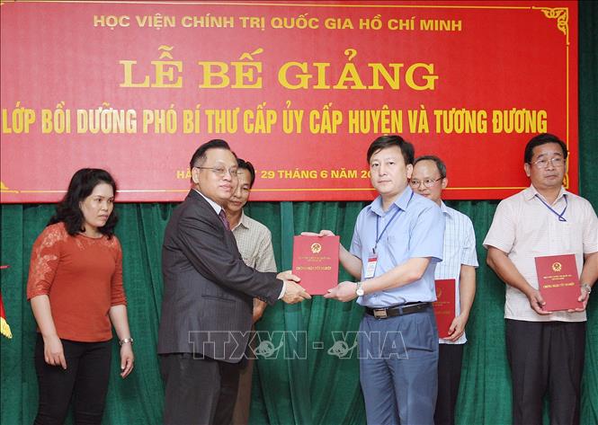 Trong ảnh: Phó Giáo sư, Tiến sĩ Lê Quốc Lý, Phó Giám đốc Học viện Chính trị quốc gia Hồ Chí Minh trao Chứng nhận tốt nghiệp cho các học viên Lớp bồi dưỡng Phó Bí thư cấp ủy cấp huyện và tương đương tại lễ bế giảng, ngày 29/6/2018. Ảnh: Nguyễn Dân – TTXVN