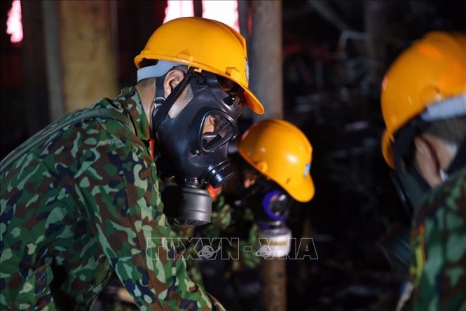 Trong ảnh: Lực lượng Binh chủng Hoá học thu gom chất thải, giải phóng hiện trường để tiến hành tẩy độc mặt nền nhà xưởng. Ảnh: Dương Giang - TTXVN