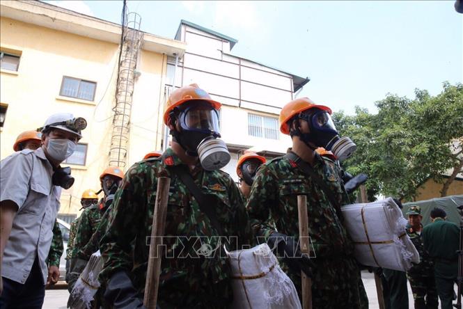 Trong ảnh: Lực lượng Binh chủng Hoá học chuẩn bị tiến hành xử lý tẩy độc khu vực cháy. Ảnh: Dương Giang - TTXVN