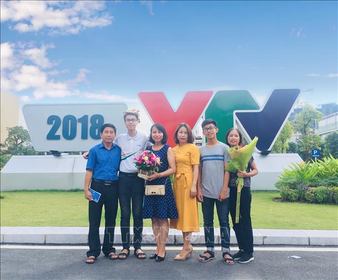 Nhà vô địch Olympia lần thứ 19 Trần Thế Trung (thứ 2 từ trái sang) với mẹ và thầy cô trường THPT chuyên Phan Bội Châu. Ảnh: Bích Huệ - TTXVN