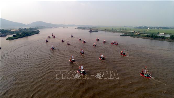 Photo: An overview of the military parade with the participation of 1,500 fishermen and martial artists along with around 50 boats on Luc Dau River. VNA Photo: Mạnh Tú