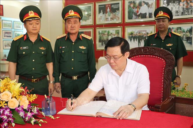 Phó Thủ tướng Vương Đình Huệ viết sổ cảm tưởng tại nhà lưu niệm Binh đoàn 15. Ảnh: Hoài Nam – TTXVN.