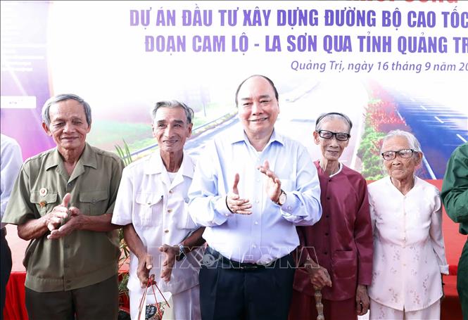 Trong ảnh: Thủ tướng Nguyễn Xuân Phúc tặng quà cho nhân dân vùng dự án. Ảnh: Thống Nhất-TTXVN
