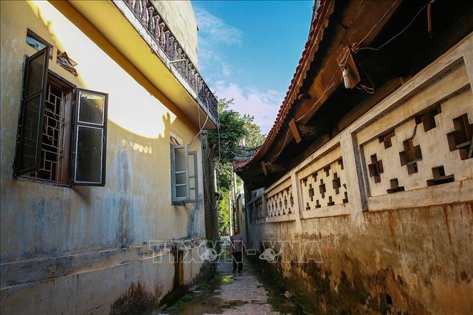 Trong ảnh: Một lối đi nhỏ hẹp bên cạnh đình làng Bát Tràng, có lẽ những con đường nhỏ quanh co và hẹp ở làng cổ Bát Tràng là một điều đặc biệt. Ảnh: Trọng Đạt - TTXVN