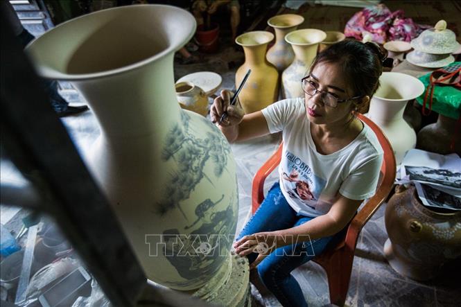 Trong ảnh: Công đoạn tạo hoa văn cho sản phẩm gốm. Ảnh: Trọng Đạt - TTXVN