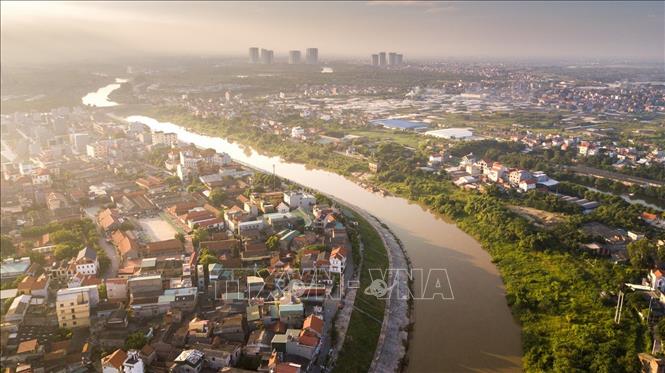 Trong ảnh: Nằm bên bờ tả ngạn sông Hồng, làng cổ Bát Tràng là làng nghề truyền thống nổi tiếng và lâu đời nhất ở Việt Nam về các sản phẩm từ gốm sứ. Năm 1958, nhà nước thực hiện đào sông Bắc Hưng Hải - Đại thuỷ nông Bắc Hưng Hải làm thuỷ lợi tưới tiêu cho một vùng đồng ruộng rộng lớn của 3 tỉnh: Bắc Ninh, Hưng Yên, Hải Dương, tạo ra thêm một con đường mới đi vào xã Bát Tràng bằng đường sông. Ảnh: Trọng Đạt - TTXVN