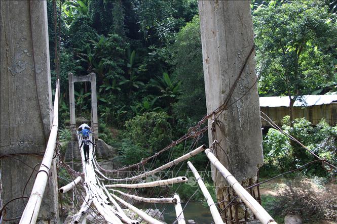 Trong ảnh: Người dân qua cầu treo nguy hiểm. Ảnh: Đinh Hương - TTXVN 