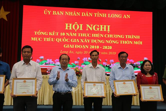 Trong ảnh: Lãnh đạo Sở NN & PTNT tỉnh Long An trao tặng bằng khen cho các tập thể đạt thành trong phong trào thi đua xây dựng nông thôn mới. Ảnh: Thanh Bình- TTXVN