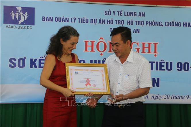 Trong ảnh: Bà Paula Isabel Morgan, Phó Giám đốc Văn phòng CDC Hoa Kỳ tại Việt Nam tặng giấy khen cho các tập thể đã thực hiện tốt dự án hỗ trợ phòng chống HIV/AIDS. Ảnh: Thanh Bình - TTXVN

