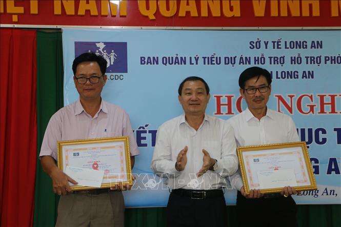 Trong ảnh: Lãnh đạo Sở Y tế  tỉnh Long An trao tặng bằng khen cho các tập thể đã thực hiện tốt Dự án hỗ trợ phòng chống HIV/AIDS. Ảnh: Thanh Bình - TTXVN
