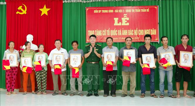 Trong ảnh: Lãnh đạo BĐBP Sóc Trăng trao tặng cờ và ảnh bác Hồ cho ngư dân vùng ven biển Sóc Trăng. Ảnh: Trung Hiếu-TTXVN
