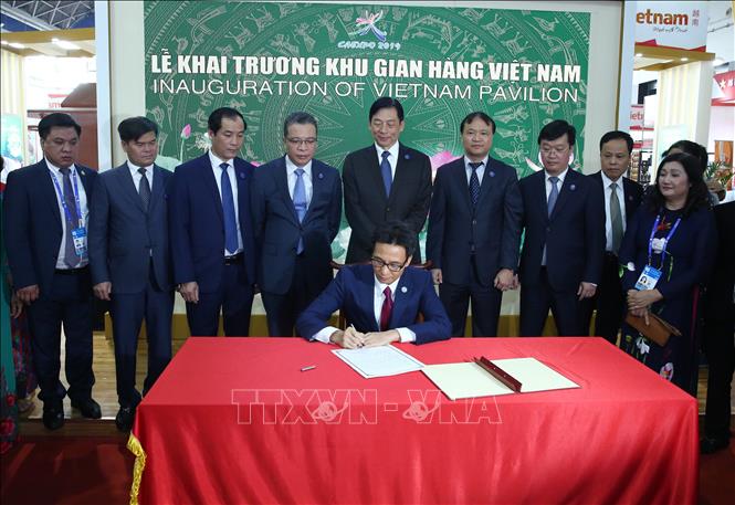 Trong ảnh: Phó Thủ tướng Chính phủ Vũ Đức Đam viết lưu bút vào sổ tại Hội chợ CAEXPO.  Ảnh: Lương Anh Tuấn-Pv TTXVN tại Trung Quốc  