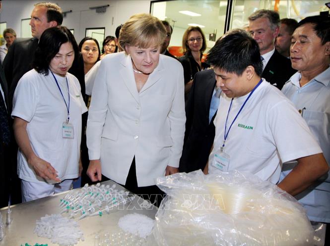 Trong ảnh: Nhân chuyến thăm chính thức Việt Nam, ngày 11/10/2011, Thủ tướng Đức Angela Merkel đến thăm và cắt băng khánh thành nhà máy sản xuất thiết bị y tế B.Braun, doanh nghiệp 100% vốn đầu tư của Đức, tại Cụm công nghiệp Thanh Oai (Hà Nội). Ảnh: Nguyễn Dân - TTXVN