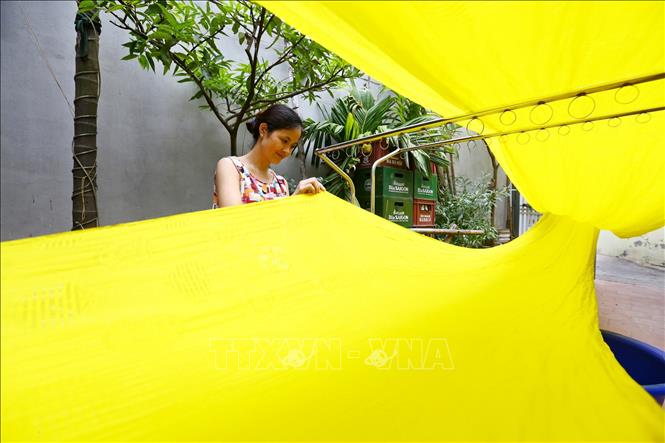 Trong ảnh: Lụa sau khi nhuộm được đem ra phơi. Với tốc độ đô thị hóa như hiện nay, lụa chỉ được phơi trong không gian chật hẹp tại sân nhà. Ảnh: Minh Quyết – TTXVN