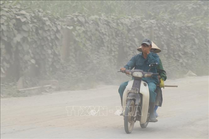 Trong ảnh: Những người công nhân đi làm hàng ngày trong khu công nghiệp bị ảnh hưởng ô nhiễm khói bụi. Ảnh: Quốc Khánh - TTXVN
