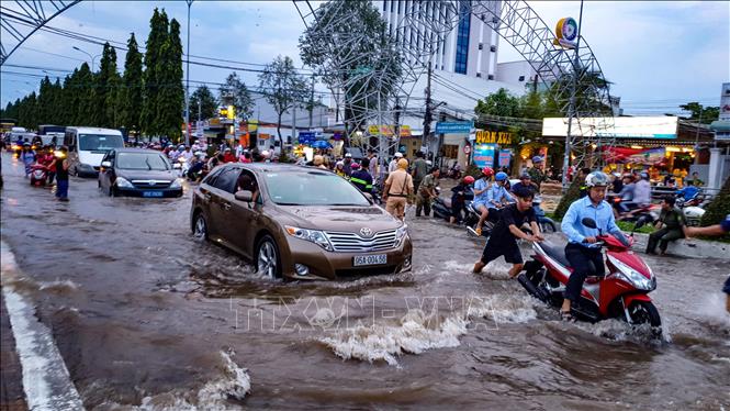 Các phương tiện di chuyển khó khăn do triều cường dâng cao trên đường Nguyễn Văn Cừ. Ảnh: Thanh Liêm - TTXVN