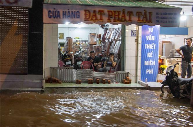 Nước ngập sâu khiến việc kinh doanh của người dân bị gián đoạn. Ảnh: Thanh Liêm - TTXVN