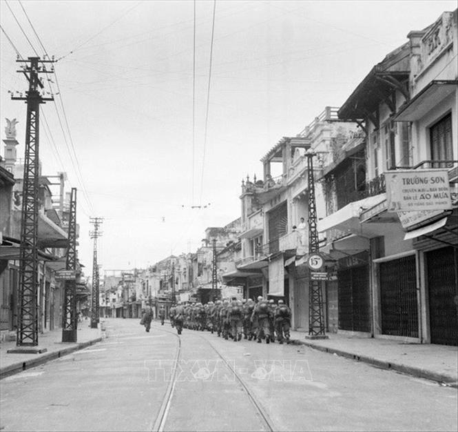 Ngày 8/10/1954, quân Pháp làm lễ hạ cờ và ngày 9/10 bắt đầu rút khỏi Hà Nội. Quân Pháp rút đến đâu, bộ đội ta tiến vào tiếp quản tới đó. Đúng 16h30 ngày 9/10/1954, quân Pháp rút hết qua cầu Long Biên, quân ta hoàn toàn kiểm soát thành phố. Trong ảnh: Lực lượng bộ binh Pháp lặng lẽ rút qua phố Hàng Đào lên cầu Long Biên để xuống Hải Phòng, chiều 9/10/1954. Ảnh: Tư liệu TTXVN