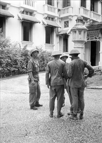 Sáng 9/10/1954, Quân đội nhân dân Việt Nam theo nhiều đường, từ ngoại thành tiến vào Hà Nội, lần lượt tiếp quản ga Hàng Cỏ, Phủ Toàn quyền cũ, khu Đồn Thủy, khu Bờ Hồ, Bắc Bộ phủ. Trong ảnh: Một sĩ quan Pháp (bên trái) có nhiệm vụ hướng dẫn Quân đội nhân dân Việt Nam tiếp thu trụ sở Bộ Tài chính (nay là Bộ Ngoại giao), ngày 9/10/1954. Ảnh: Tư liệu TTXVN