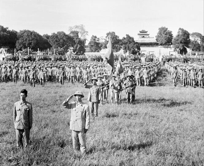 Trong ảnh: Thiếu tướng Vương Thừa Vũ (bên phải), Tư lệnh Đại đoàn 308 (nay là Sư đoàn 308 - Sư đoàn Quân Tiên phong), Chủ tịch Ủy ban Quân chính Thành phố và bác sĩ Trần Duy Hưng (bên trái), Phó Chủ tịch Ủy ban Quân chính cùng các đơn vị thuộc Đại đoàn 308 tiếp quản Hà Nội tiến hành nghi lễ chào cờ đầu tiên trong Ngày giải phóng Thủ đô, diễn ra tại sân Cột Cờ (nay là Đoan Môn - Hoàng thành Thăng Long) vào lúc 15 giờ ngày 10/10/1954. Ảnh: Tư liệu TTXVN