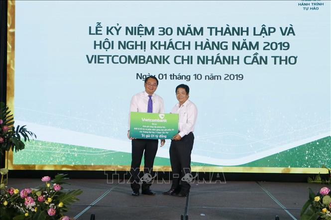 Giám đốc Vietcombank Cần Thơ Trần Long Giang (bên trái) trao bảng tượng trưng số tiền 1 tỷ đồng tài trợ cho đại diện Trường Đại học Y dược Cần Thơ. Ảnh: Thanh Liêm - TTXVN