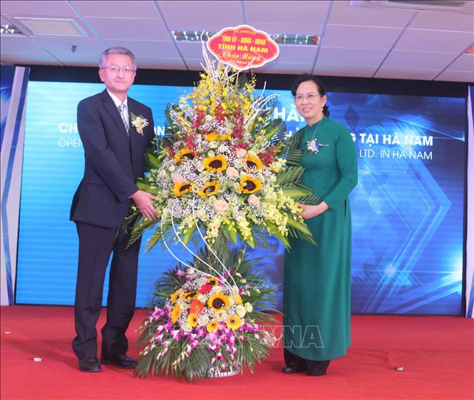 Trong ảnh: Bà Lê Thị Thủy, Bí thư Tỉnh ủy Hà Nam, tặng hoa chúc mừng Công ty TNHH Ojietex Hải Phòng. Ảnh: Nguyễn Chinh - TTXVN
