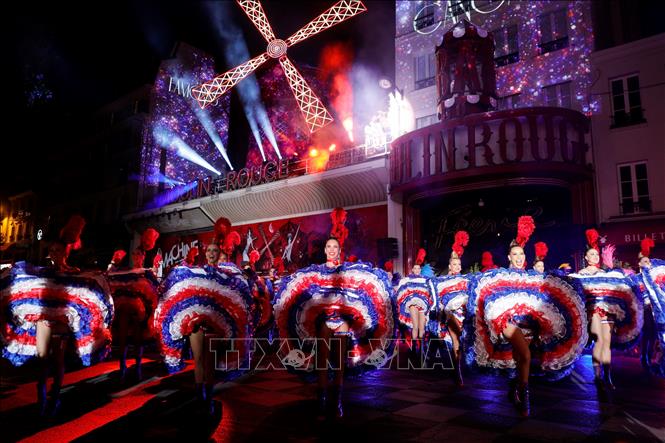 Trong ảnh: Các vũ công biểu diễn bên ngoài nhà hát Moulin Rouge ở Paris. Ảnh: AFP/TTXVN