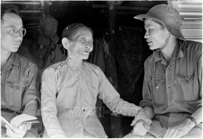 Trong ảnh: Phóng viên Thanh Phong của Thông tấn xã Giải phóng tại Quảng Trị (bên phải) nói chuyện với một gia đình nuôi cán bộ cách mạng tại thị xã Quảng Trị (1968). Ảnh: TTXVN