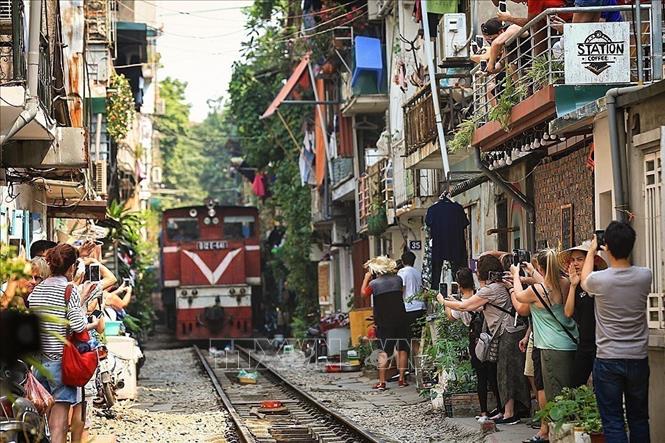 Photo: Photo: A South-North train runs through the street. VNA Photo: Trọng Đạt