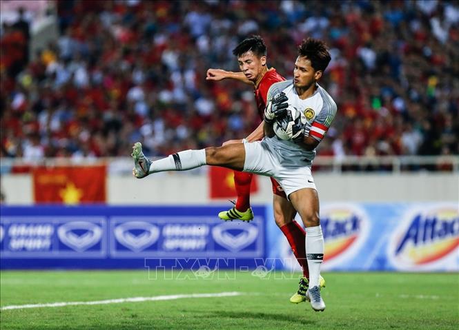 Trong ảnh: Pha tranh bóng với thủ môn đối phương của hậu vệ Bùi Tiến Dũng. Ảnh: Trọng Đạt – TTXVN 