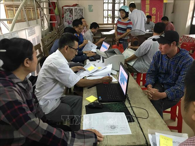 Trong ảnh: Cán bộ ngành Tài nguyên và Môi trường làm thủ tục cho người dân thôn Hữu Thanh Oai, xã Hữu Hoà, huyện Thanh Trì kê khai đất đai, tài sản gắn liền với đất trong quy trình kiểm kê đất đai và lập bản đồ hiện trạng sử dụng đất. Ảnh: Trọng Đạt – TTXVN