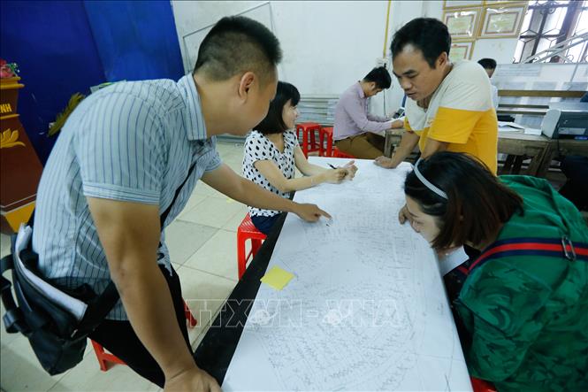 Trong ảnh: Người dân thôn Hữu Thanh Oai, xã Hữu Hoà, huyện Thanh Trì kiểm tra, đối chiếu số liệu, thông tin đất đai trên bản đồ tại điểm làm thủ tục kiểm kê đất đai và lập bản đồ hiện trạng sử dụng đất. Ảnh: Trọng Đạt – TTXVN