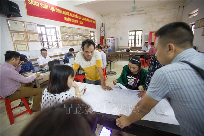 Trong ảnh: Cán bộ ngành Tài nguyên và Môi trường làm thủ tục cho người dân thôn Hữu Thanh Oai, xã Hữu Hoà, huyện Thanh Trì kê khai đất đai, tài sản gắn liền với đất trong quy trình kiểm kê đất đai và lập bản đồ hiện trạng sử dụng đất. Ảnh: Trọng Đạt – TTXVN