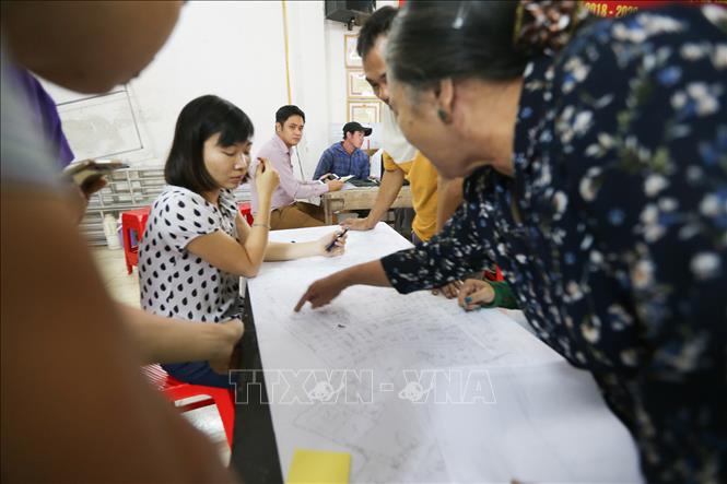 Trong ảnh: Người dân thôn Hữu Thanh Oai, xã Hữu Hoà, huyện Thanh Trì kiểm tra, đối chiếu số liệu, thông tin đất đai trên bản đồ tại điểm làm thủ tục kiểm kê đất đai và lập bản đồ hiện trạng sử dụng đất. Ảnh: Trọng Đạt – TTXVN