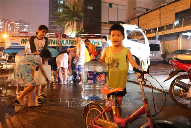 Trong ảnh: Các em nhỏ tại Khu đô thị Hapulico (Thanh Xuân Trung) phụ giúp người lớn lấy nước sạch lúc nửa đêm. Ảnh: Thành Đạt - TTXVN