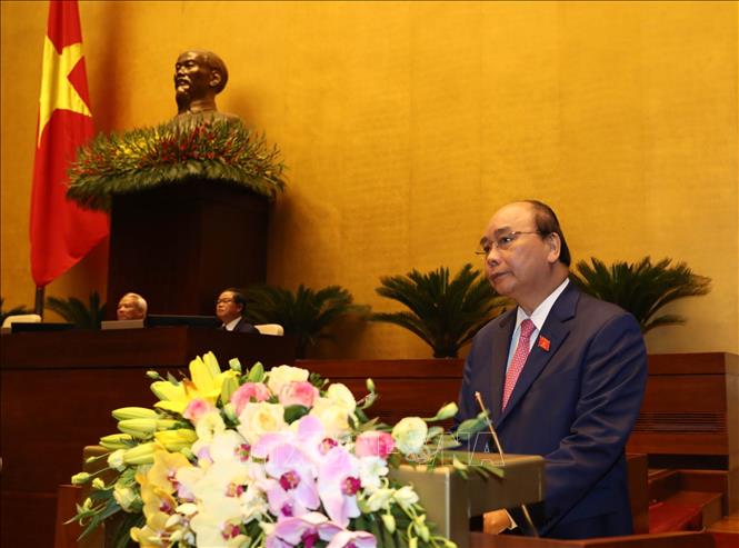 Trong ảnh: Thủ tướng Nguyễn Xuân Phúc đọc báo cáo của Chính phủ.  Ảnh: Trọng Đức - TTXVN